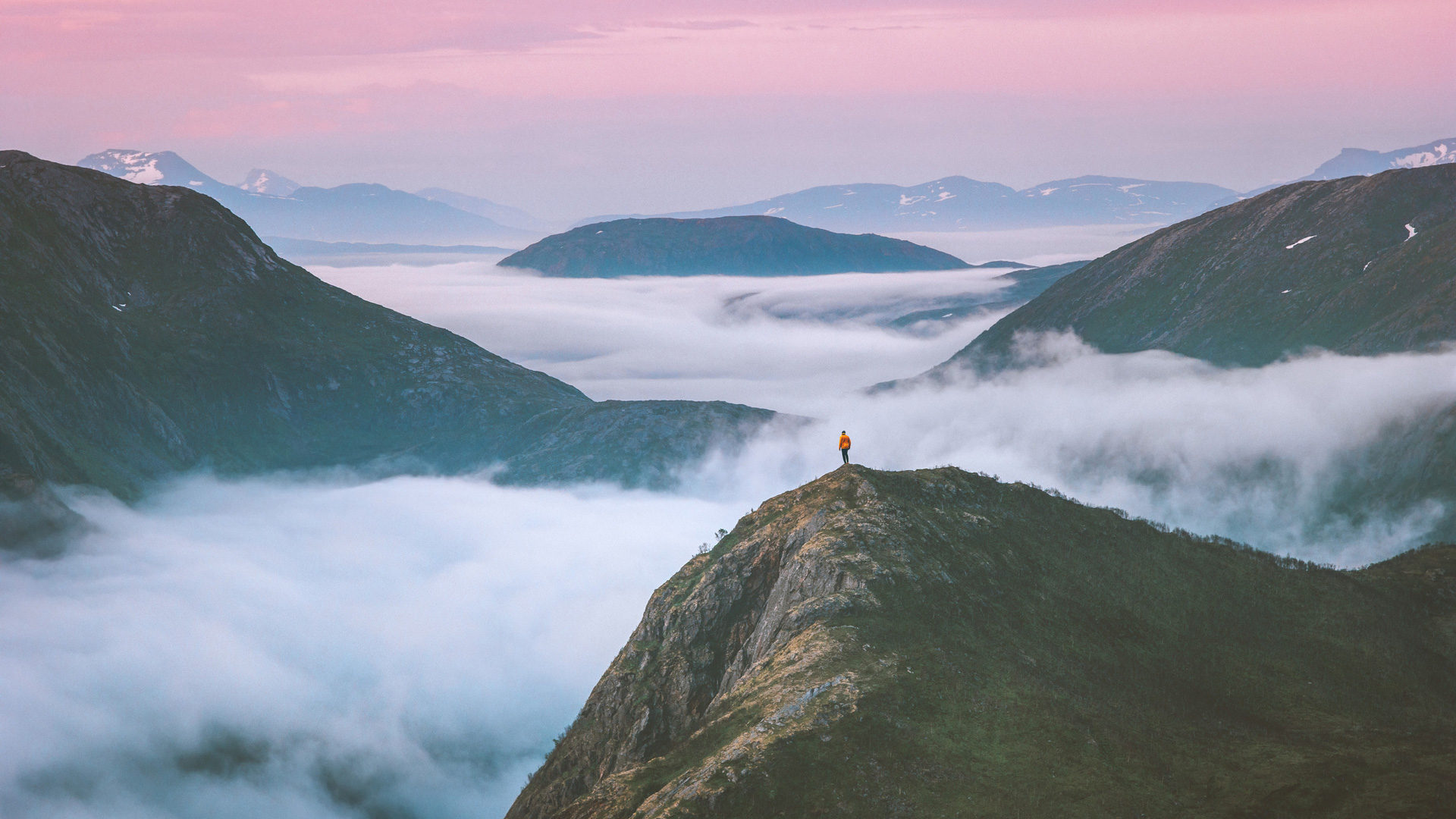 hiker above mountain clouds enjoying sunset landscape