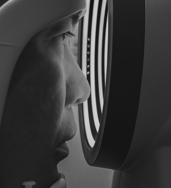 Black and white image of person looking into machineary