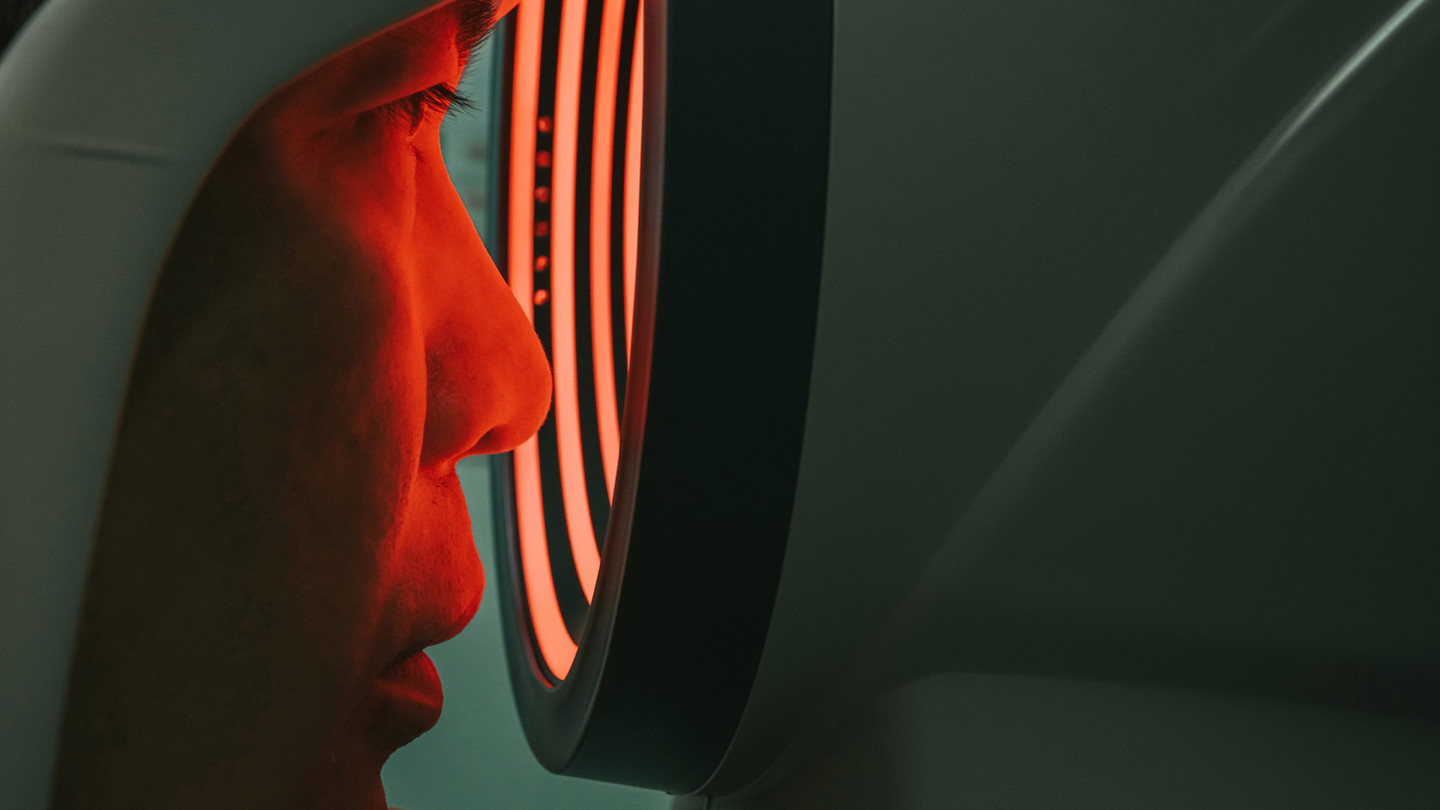 Person looking into red ring from a piece of medical machineary