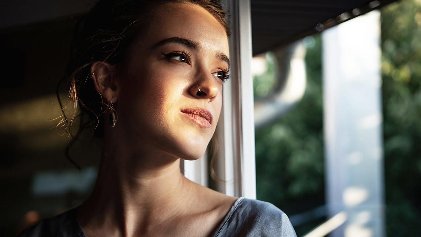 Young woman looking out of a window