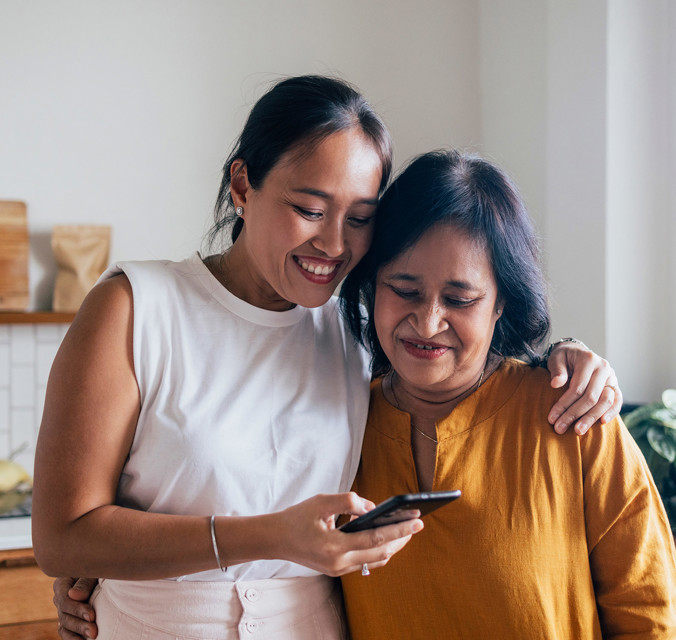 Older and younger woman looking at a phone
