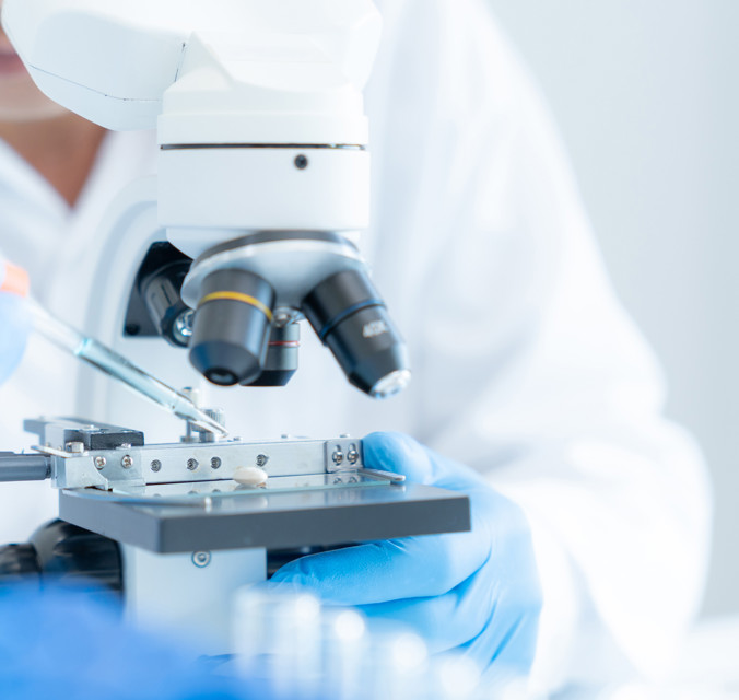 Someone pipetting into microscope