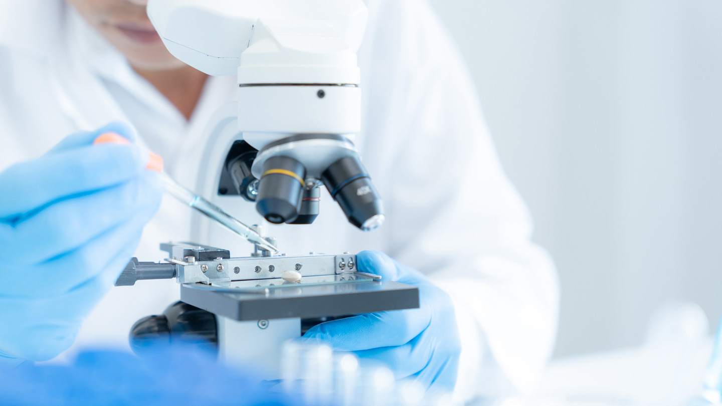 Someone pipetting into microscope